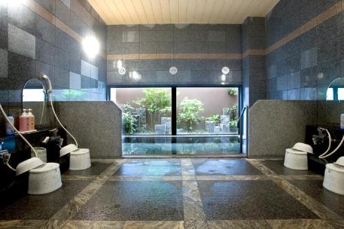 a bathroom with two sinks and a large window at Hotel Route-Inn Hofu Ekimae in Hofu