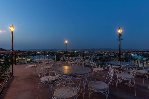 a patio with tables and chairs on a balcony at night at Hotel Mewari Villa PURE VEG in Udaipur