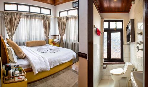 a bedroom with a bed and a bathroom with a toilet at Shangri-la Boutique Hotel in Kathmandu