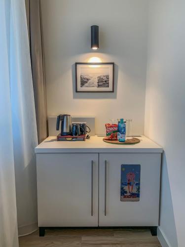 a white cabinet with a coffee maker on top of it at Insel Hotel Bonn - Superior in Bonn