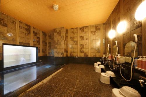 a bathroom with two toilets and a flat screen tv at Hotel Route-Inn Sakaide-Kita Inter in Sakaide