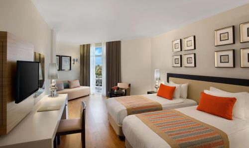 a hotel room with two beds and a television at Akka Alinda Hotel - Premium Ultra All Inclusive in Kemer