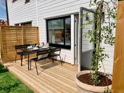 a wooden deck with a dining table on it at Easy Livin' Apartment Hotel in Växjö