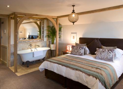 a bedroom with a large bed and a large mirror at The Farmhouse Hotel and Restaurant in St Saviour Guernsey
