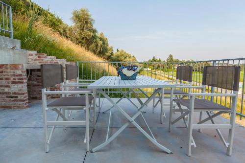 a table with two chairs and a vase of flowers on it at Viale Asiago 288 in Bassano del Grappa