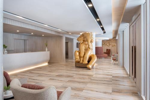 a lobby with a statue in the middle of it at Eleven Hotel Bangkok Sukhumvit 11 in Bangkok