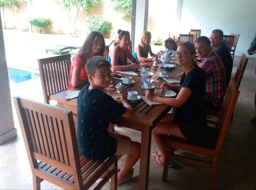 a group of people sitting around a wooden table at Honey Tree Polonnaruwa in Polonnaruwa