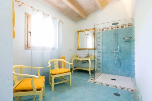 a bathroom with a shower and two chairs and a sink at Agriturismo Famiglia al Castello Di Bagnolo in Bagnolo Piemonte