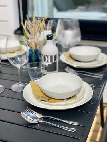 a black table with plates and silverware on it at Easy Livin' Apartment Hotel in Växjö