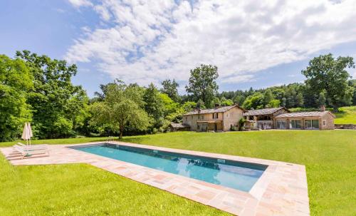 a large yard with a swimming pool and a house at Agriturismo Famiglia al Castello Di Bagnolo in Bagnolo Piemonte