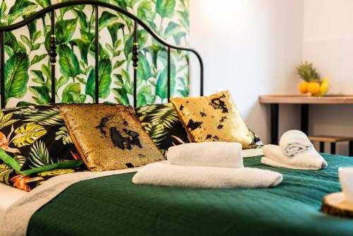 a green bed with towels on top of it at Lu Apartments in Oświęcim