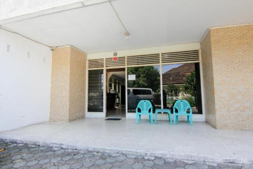 two blue chairs sitting outside of a building at Lestari Guesthouse in Padang