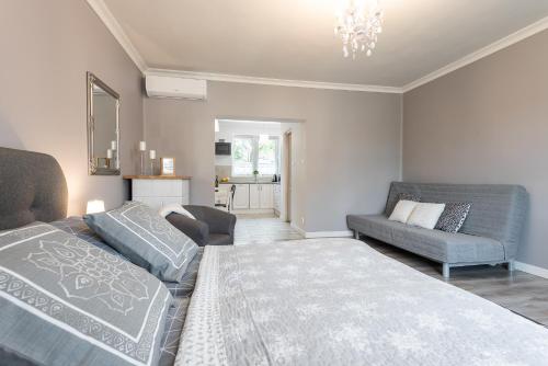 a bedroom with a bed and a couch and a chair at Lu Apartments in Oświęcim