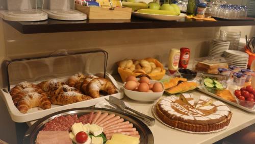 a table with many different types of food on it at Hotel Losanna in Milan