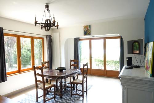 comedor con mesa de madera y sillas en Maison du Buis doré en Pollieu
