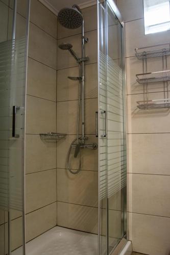 a bathroom with a shower with a glass door at MGE Luxury house with pool in Iraklitsa