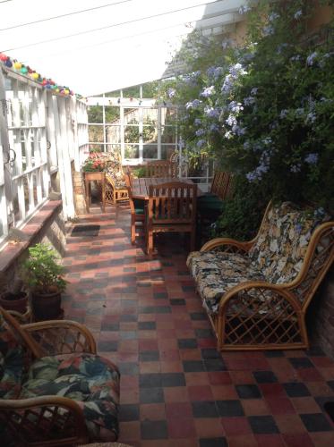 a patio with chairs and tables on a porch at Baron's Grange in Iden