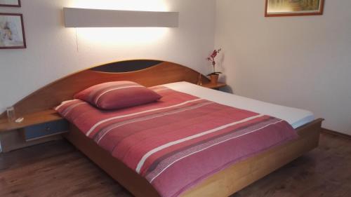 Hotel Römerhof في ساربروكن: غرفة نوم مع سرير مع لوح خشبي للرأس