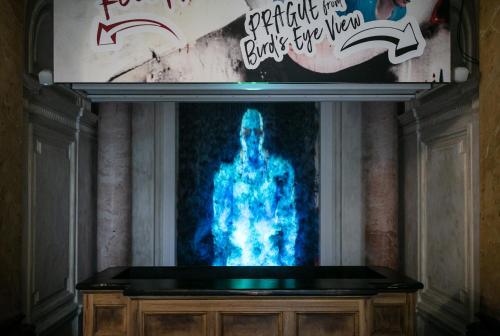 a tv screen with a picture of a man at MeetMe23 in Prague