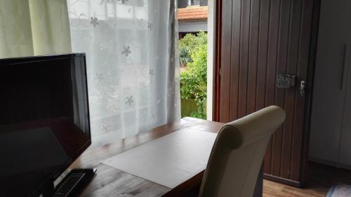 a room with a desk with a chair and a television at Hotel Römerhof in Saarbrücken