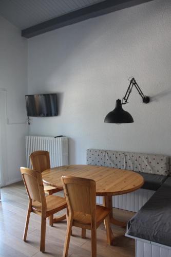 une table en bois avec quatre chaises et une lampe dans l'établissement STUDIO CHAMONIX MONT-BLANC Idéalement situé, à Chamonix-Mont-Blanc