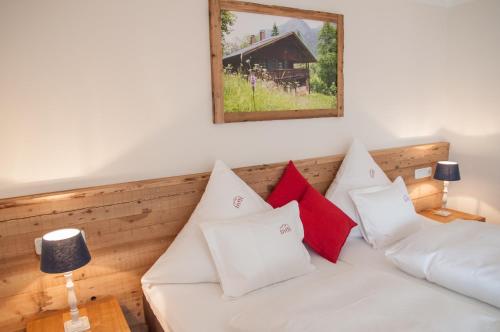 una sala de estar con un sofá blanco con almohadas rojas en Allgäu Spitze, en Oberstdorf