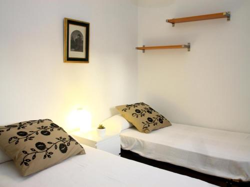two beds in a room with white walls at Saavedra Free Parking Cordoba Center in Córdoba