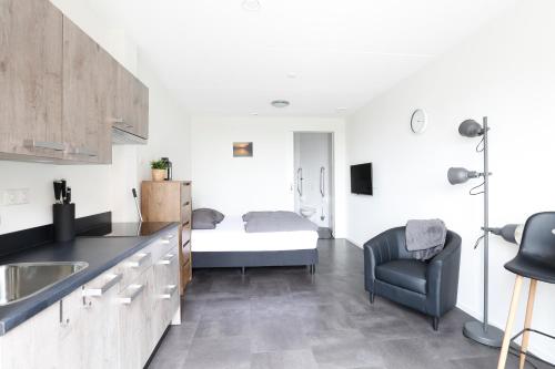 a kitchen with a sink and a bed in a room at Ut Endt Vlieland in Oost-Vlieland