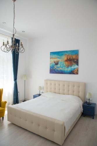 a bedroom with a large white bed and a painting at SUNNY NOVEMBER in Braşov