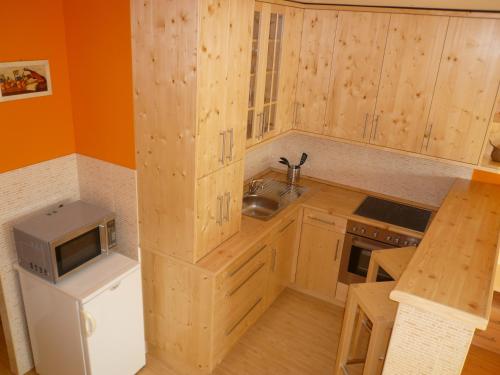 a small kitchen with wooden cabinets and a microwave at Museum View Apartment in Budapest