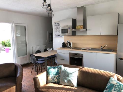 un salon avec un canapé et une cuisine dans l'établissement Gites de charme à Milly-La-Forêt, à Milly-la-Forêt