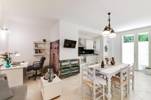 a kitchen and living room with a white table and chairs at Campus House in Forlì