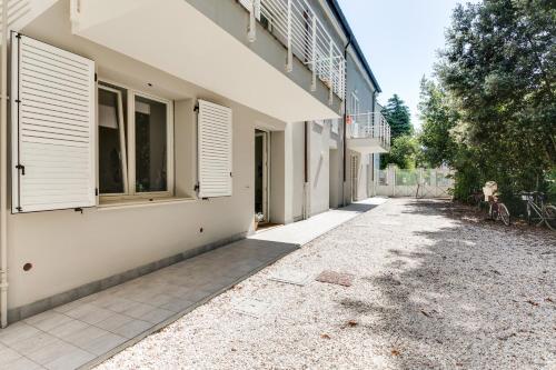 a building with white shutters on the side of it at Campus House in Forlì