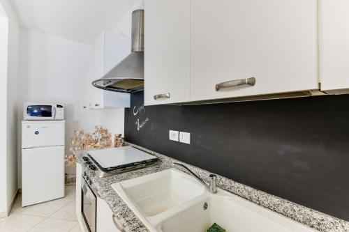a kitchen with a sink and a black wall at Campus House in Forlì
