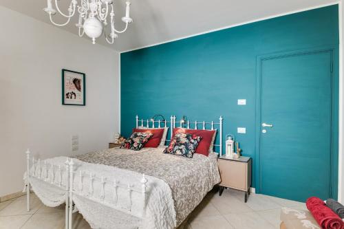 a bedroom with a bed and a blue wall at Campus House in Forlì