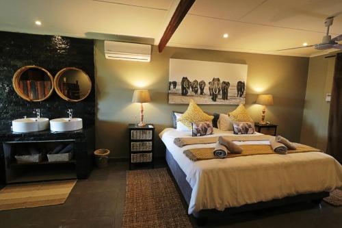 a bedroom with a large bed and two mirrors at Ngalali Retreat in Grietjie Nature Reserve