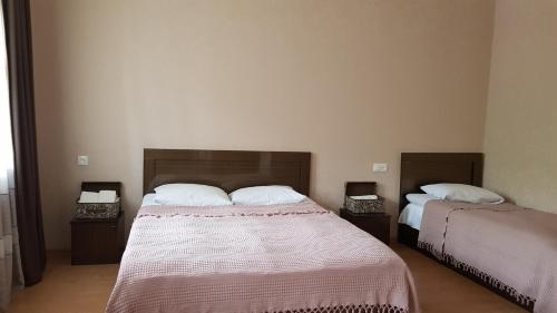 a bedroom with two beds and two night stands at Sunny Mountain House in Stepantsminda