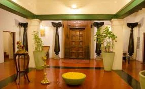 a living room with a wooden floor and a door at GeeKay Millenniaa in Vellore