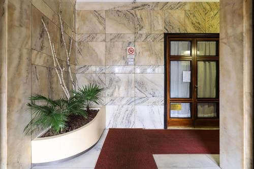 lobby z rośliną w garnku obok drzwi w obiekcie PrimoPiano - Sammartini w Mediolanie