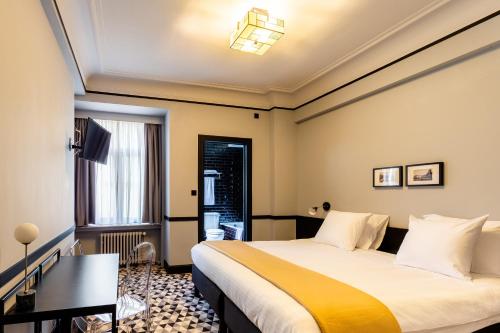 a hotel room with a bed and a window at Hotel Des Colonies in Brussels