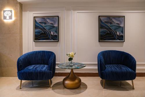 two blue chairs and a table in a room at Hanoi Fiesta Central Hotel and Spa in Hanoi