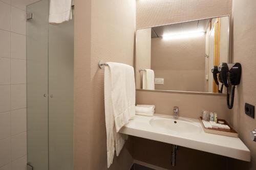 La salle de bains est pourvue d'un lavabo et d'un miroir. dans l'établissement DC HOTEL INTERNATIONAL, à Padoue