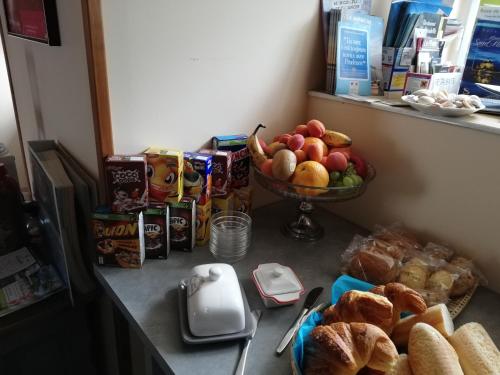a counter with a bowl of bread and a bowl of fruit at La Parisiere in Gavray