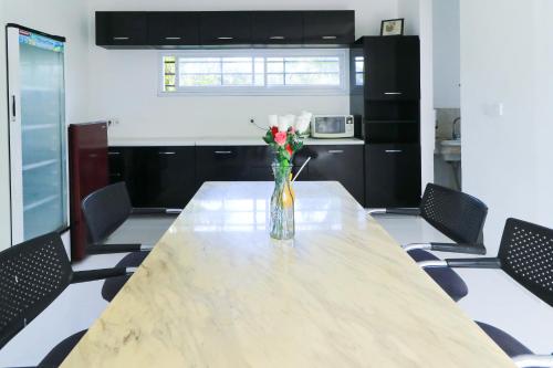 a table with a vase of flowers in a room at Margarita Surf Hostel Canggu in Canggu