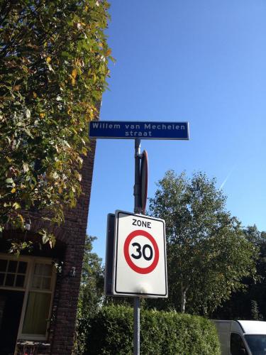 a street sign with a speed limit sign on a street at Hotel Randenbroek in Amersfoort