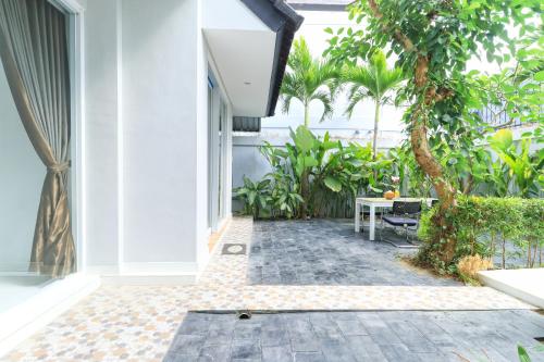 an internal courtyard of a house with a table and trees at Margarita Surf Hostel Canggu in Canggu