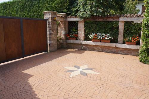 a brick patio with a flower in the middle at LA BRIGATA APARTMENTS Suite Room in Cavallino-Treporti