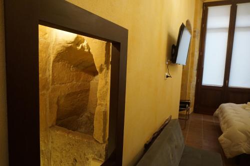 uma lareira de pedra num quarto com uma cama em PALAZZO FULGHER em Cagliari