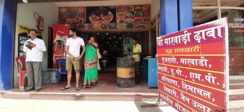 een groep mensen die buiten een winkel staan bij Hotel Prakash in Rāmeswaram