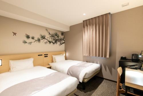 a hotel room with two beds and two lamps at La'gent Hotel Shinjuku Kabukicho in Tokyo